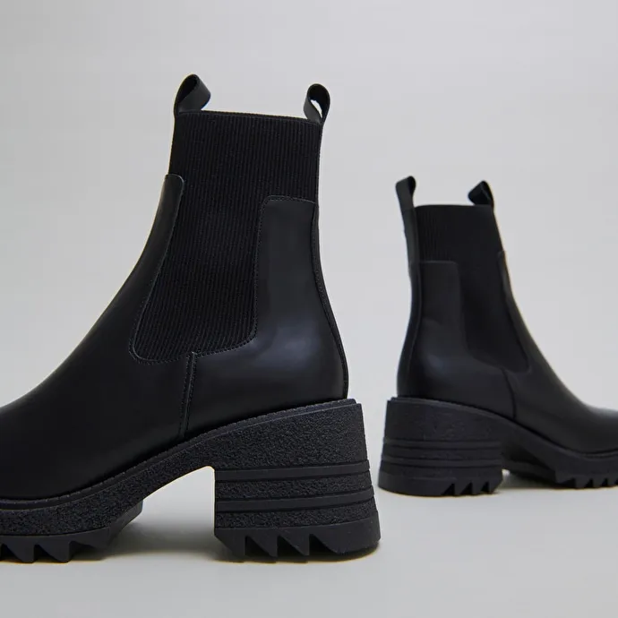 Boots with elastics and notched sole in glazed black leather